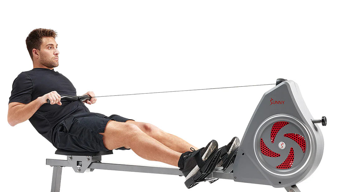 Man using a rowing machine on a white background